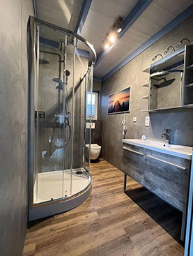 Fertiges Bad mit Eckdusche, fugenloser Wand und Holzboden