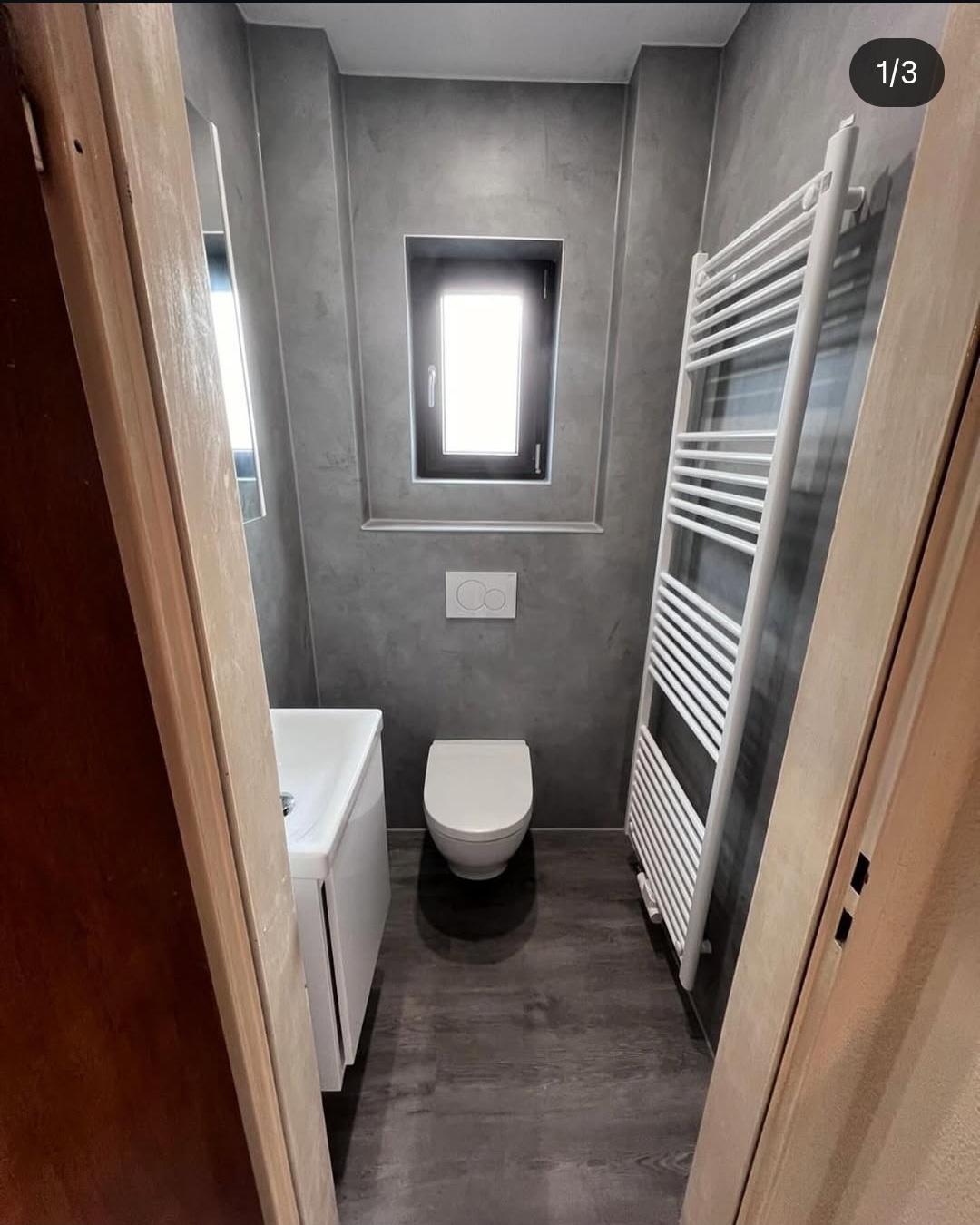 Fugenloses Gäste-WC in Betonoptik mit Wand-WC und Handtuchheizkörper