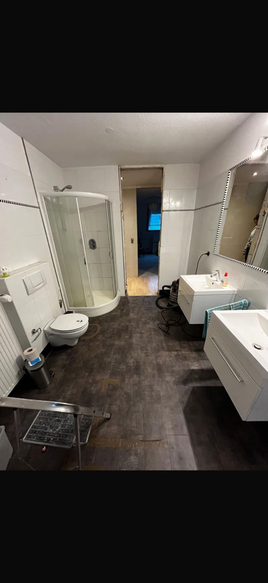 Badezimmer vor dem Umbau mit alten weißen Fliesen und Eckdusche